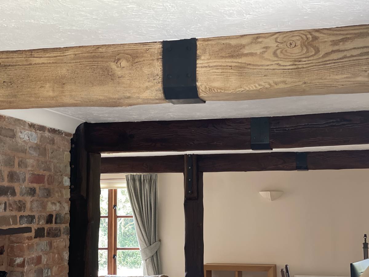 Dark-stained beams restored to natural timber in a Potton Gransden self-build in Bedfordshire